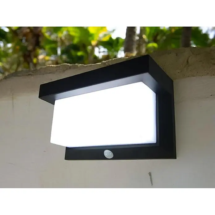 DAPO Solar-Außenwandleuchte Solar-Wandleuchte "All weather" - L x B x H: 9 x 21 x 12 cm, IP44 - Schwarze Außenwandleuchte mit weißem Diffusor und Bewegungssensor an einer strukturierten Wand.