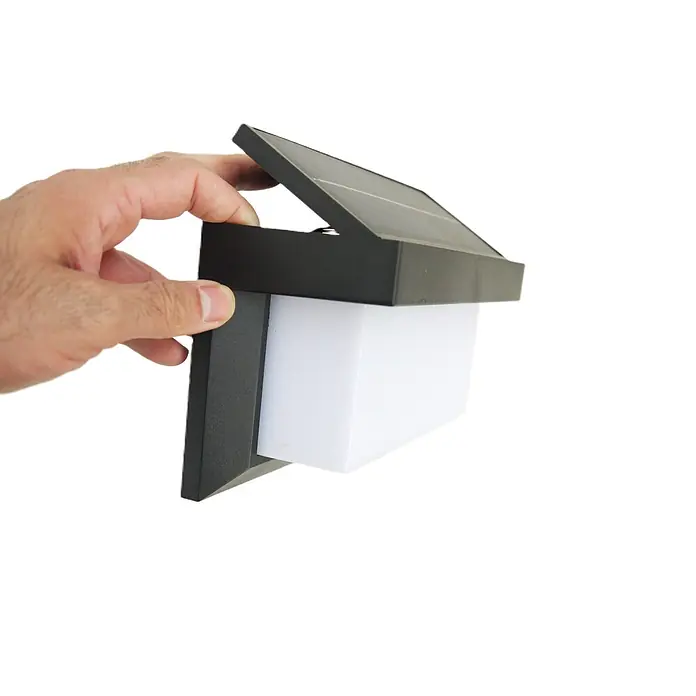 DAPO Solar-Außenwandleuchte Solar-Wandleuchte "All weather" - L x B x H: 9 x 21 x 12 cm, IP44 - Schwarze Solar-Wandleuchte mit weißem Diffusor, von einer Hand gehalten, zeigt ihr verstellbares Solarpanel.