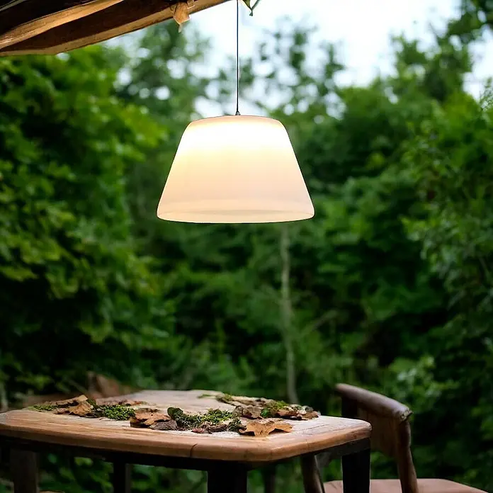 Solar Hängeleuchte Jolla -  - Weiße gefrostete Outdoor-Pendelleuchte beleuchtet einen Holztisch im Gartenambiente.