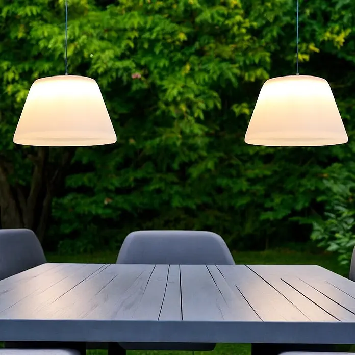 Solar Hängeleuchte Jolla -  - Zwei weiße, lichtdurchlässige Pendelleuchten hängen über einem grauen Gartentisch mit Stühlen.