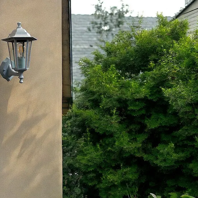 DAPO Außenwandleuchte Außen Wandleuchte Kingston Weiß Fassung E27 - 60 W, 19,5 x 22 x 33 cm, Schwarz, Klar, IP44 - Graue Metall-Außenwandleuchte an einer Hauswand montiert.