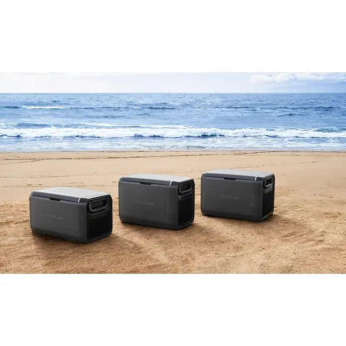EcoFlow Akku-Kühlbox Glacier - 1 Akku, L x B x H: 48 x 70,6 x 46,6 cm, 55 l - Drei graue ECOFLOW tragbare Kühlboxen/Powerstations am Sandstrand am Meer.