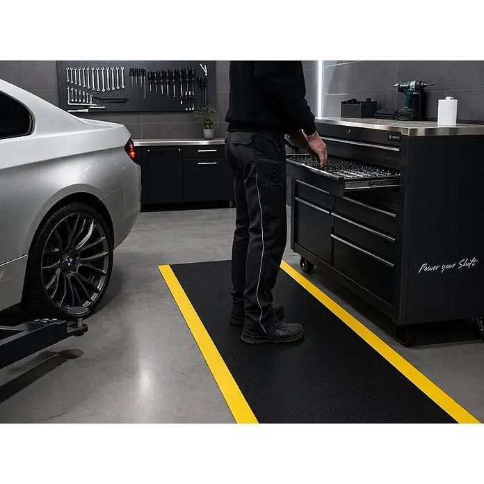 Proregal Gummimatte Anti-Ermüdungsmatte COMFORT 122x200cm Schwarz/Gelb - 200 x 122 cm, Schwarz/Gelb - Schwarze Anti-Ermüdungsmatte mit gelbem Rand auf Garagenboden, von Arbeiter an Werkzeugschrank genutzt.