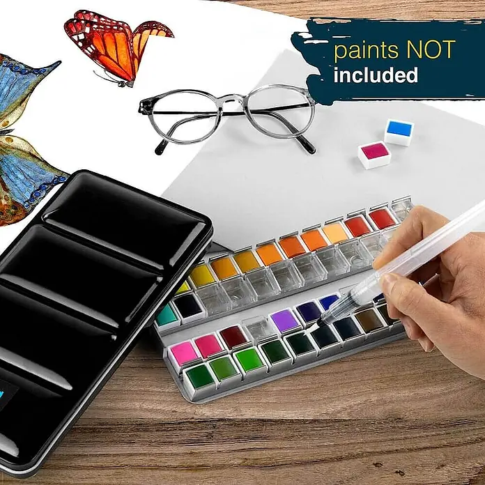 Artina Aquarellfarben-Set -  - Eine schwarze Aquarellfarbpalette und zwei Schalen mit Farbnäpfchen; eine Hand hält einen Wassertankpinsel über die Näpfchen.