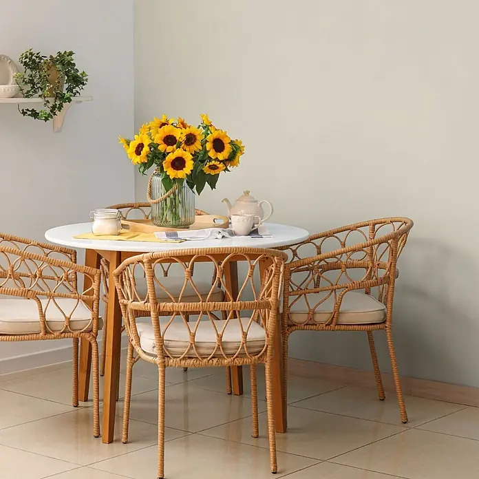 Bricoflor Wandfarbe 2,5 Liter, Sand - creme beige, Matt, 2,5 l, Wasserverdünnbar - Weißer Esstisch mit vier Rattan-Stühlen, dekoriert mit Sonnenblumen.
