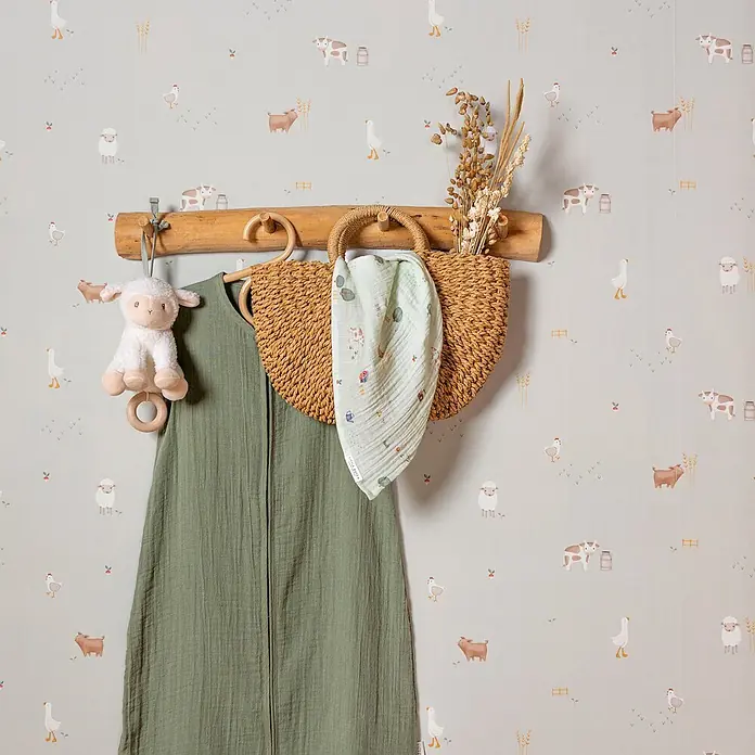 Little Dutch Vliestapete kleiner Bauernhof - Grün, Tieroptik, 10 x 0,52 m - Salbeigrüner Babyschlafsack, Strohkorb mit hellgrünem Musselintuch und Schaf-Rassel an rustikaler Holzgarderobe.