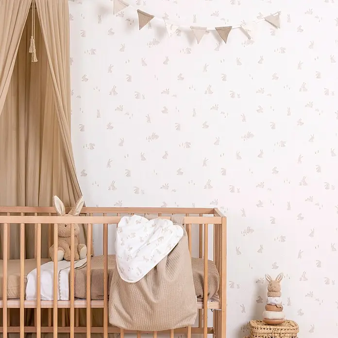 Little Dutch Vliestapete Babykaninchen - Braun/Weiß, Tieroptik, 10 x 0,52 m - Ein friedliches Babyzimmer mit heller Hasen-Tapete, einem Holzbett und weichen, neutralen Stoffen.
