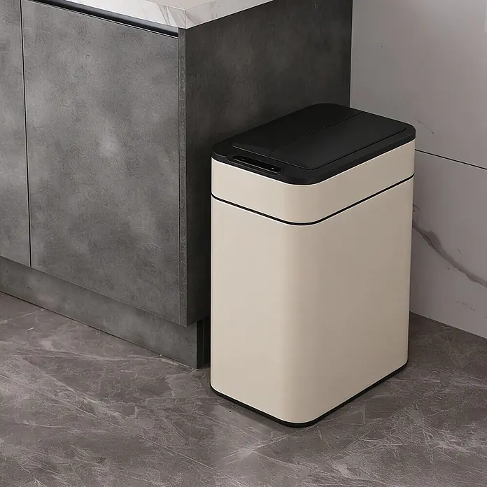 SVITA Sensormülleimer SE50L - 50 l, Stahl, Taupe - Beiger und schwarzer smarter Mülleimer mit Sensor-Deckel, neben einem dunkelgrauen Schrank in einem modernen Raum.
