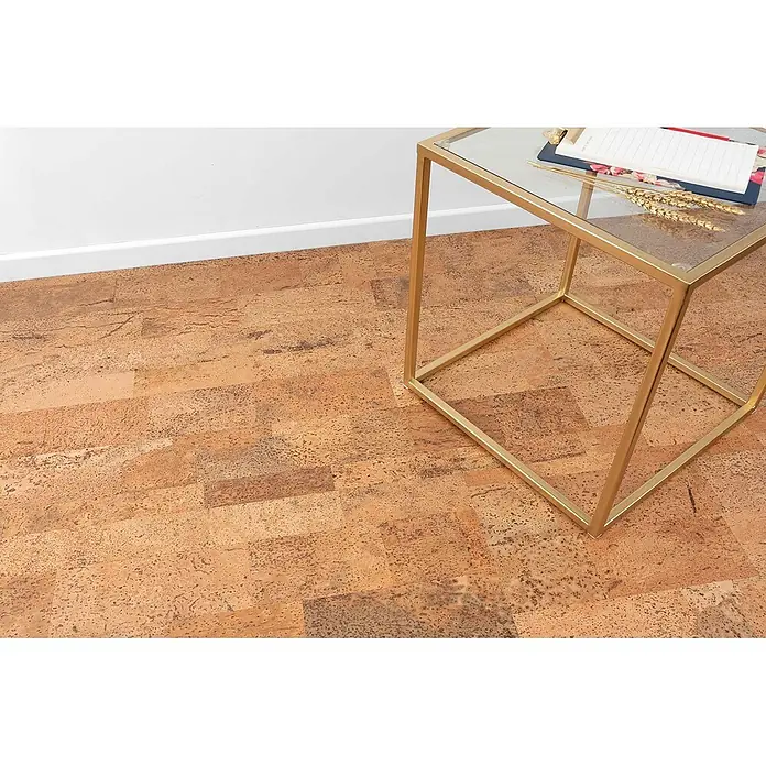 Bricoflor Korkboden Klick-System Korkparkett versiegelt, Schiffsboden natur dunkel, 2,136 qm/Ka - 295 x 905 x 10,5 mm - Natürlicher Korkboden aus rechteckigen Planken, der verschiedene Brauntöne und Texturen zeigt. Ein goldener Beistelltisch steht darauf.