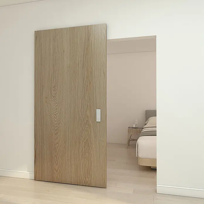 Inova Schiebetür-Komplettset Holzschiebetür Eiche mit verdeckter Laufschiene und Softclose 1030 x 2100mm - 1.030 x 2.100 mm - Helle Holz-Schiebetür, teilweise geöffnet, führt in ein Schlafzimmer.