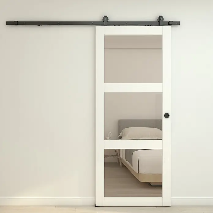 Inova Schiebetür-Komplettset Holzschiebetür Weiß mit Glaseinsatz und Softclose 1025 x 2150 mm - 1.025 x 2.150 mm - Weiße Glasschiebetür im Scheunentor-Stil mit schwarzem Schienensystem, die ein modernes Schlafzimmer zeigt.