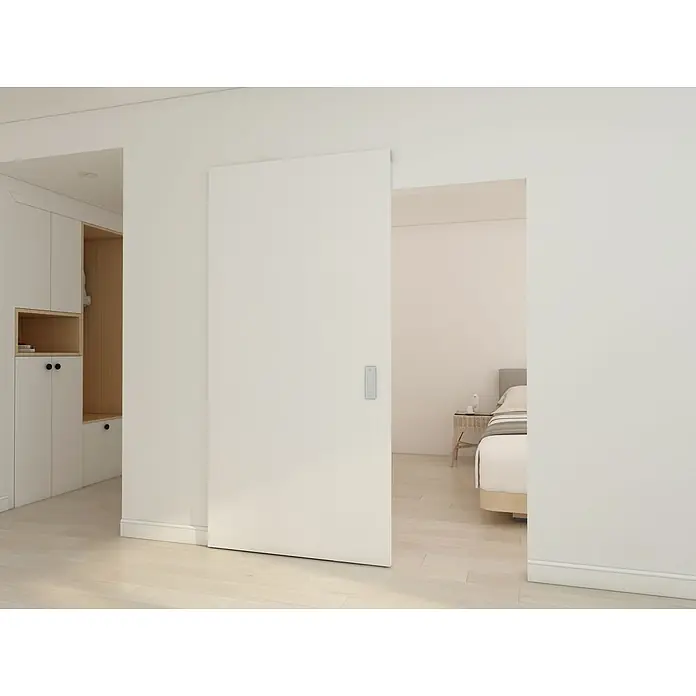 Inova Schiebetür-Komplettset Holzschiebetür Weiß mit verdeckter Laufschiene und Softclose 1030 x 2100 mm - 1.030 x 2.100 mm - Weiße Schiebetür, teilweise geöffnet, trennt Schlafzimmer und Einbauschrank, mit modernem Griff.