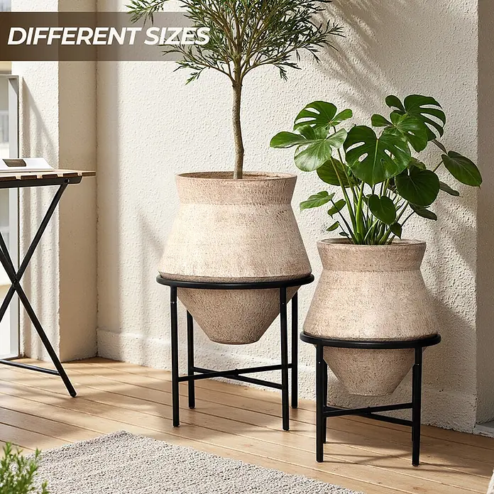 Hometopia Pflanztopf HTPL0359-BR - 2 Stk., Außenmaß (Ø x H): 62,5 x 62,5 cm, Metall, braun - Set aus zwei strukturierten beigefarbenen Pflanzgefäßen mit schwarzen Metallständern in verschiedenen Größen, auf einem Balkon mit Pflanzen.