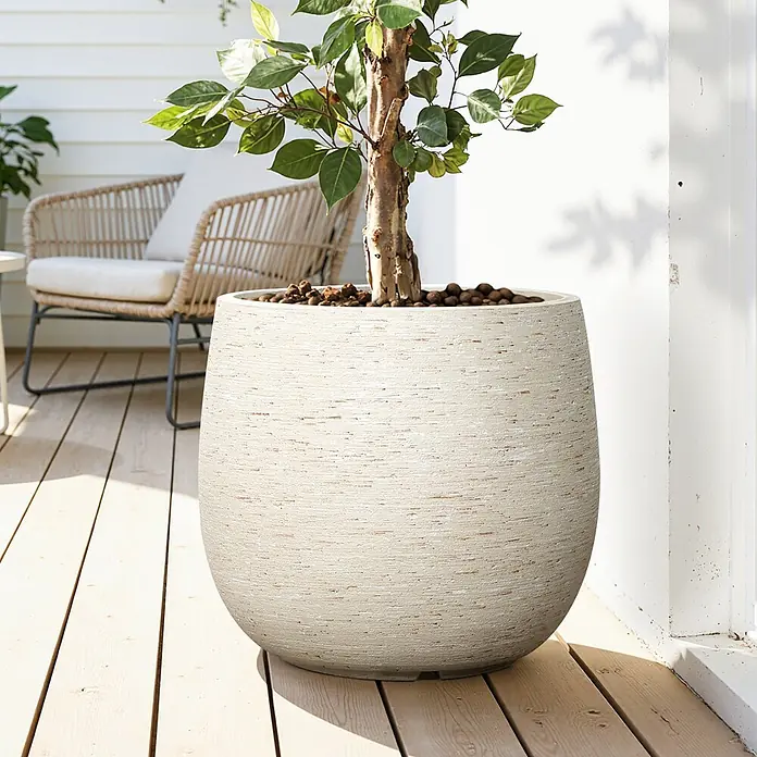 Hometopia Pflanztopf HTPL0166 - Außenmaß (Ø x H): 31 x 31,8 cm, Verbundwerkstoff, Weiß - Großer, hellbeiger, strukturierter Pflanzkübel mit Pflanze auf Holzterrasse.