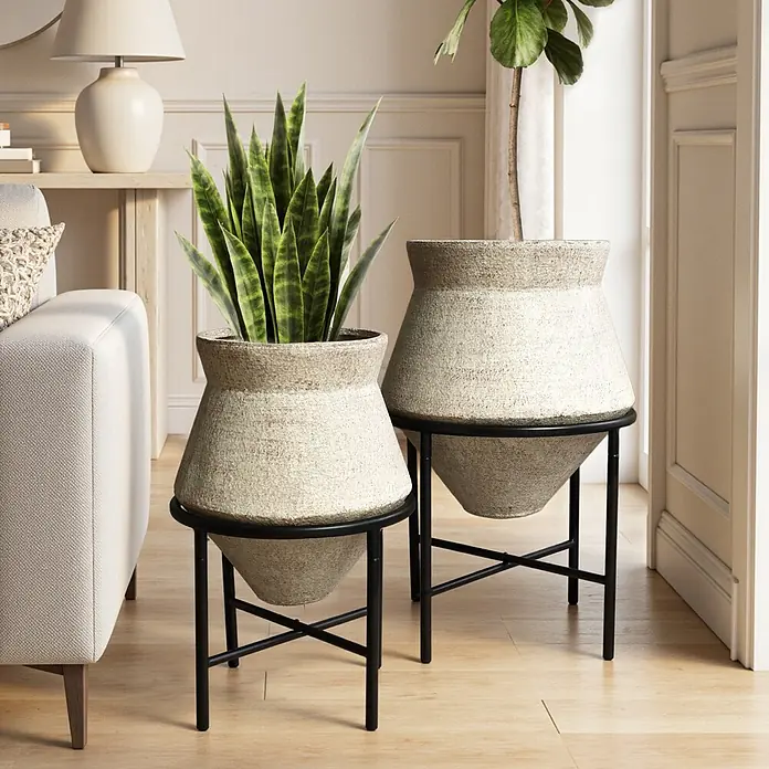 2er Blumentopf Set Frostsicher Formstabil -  - Zwei cremefarbene Pflanzgefäße auf schwarzen Metallständern, eines mit Pflanze, im Wohnzimmer dekoriert.