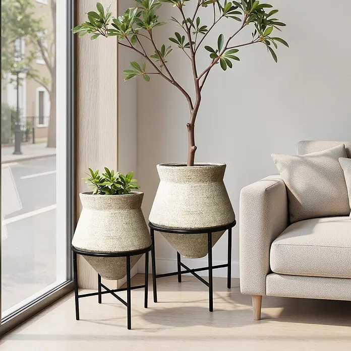 2er Blumentopf Set Frostsicher Formstabil -  - Zwei texturierte beigefarbene Pflanzgefäße mit konischem Boden in schwarzen Metallständern, unterschiedlich hoch, in einem modernen Wohnraum.
