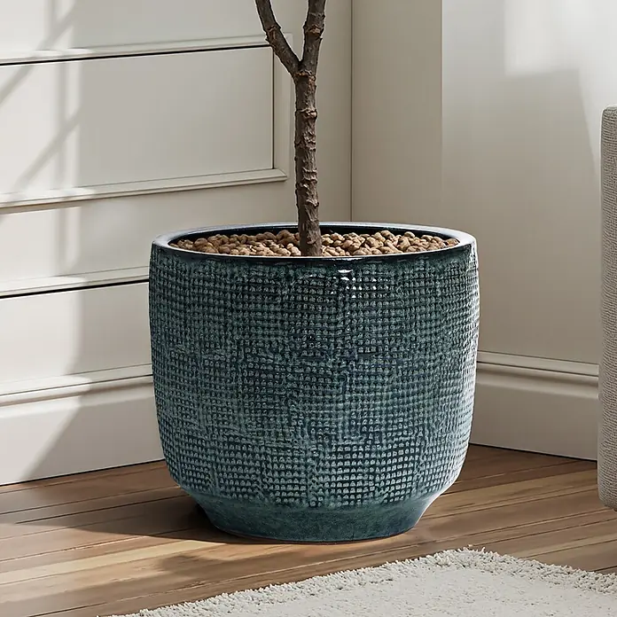 Hometopia Pflanztopf HTPL0037-L - 1 Stk., Außenmaß (Ø x H): 39 x 34 cm, Keramik - Dunkeltürkiser texturierter Keramik-Pflanztopf, eine Pflanze enthaltend, auf Holzboden neben einem weißen Schrank.