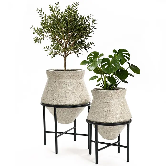 2er Blumentopf Set Frostsicher Formstabil -  - Zwei texturierte, hellfarbene Pflanzgefäße auf schwarzen Metallständern, eines höher als das andere, mit grünen Pflanzen.