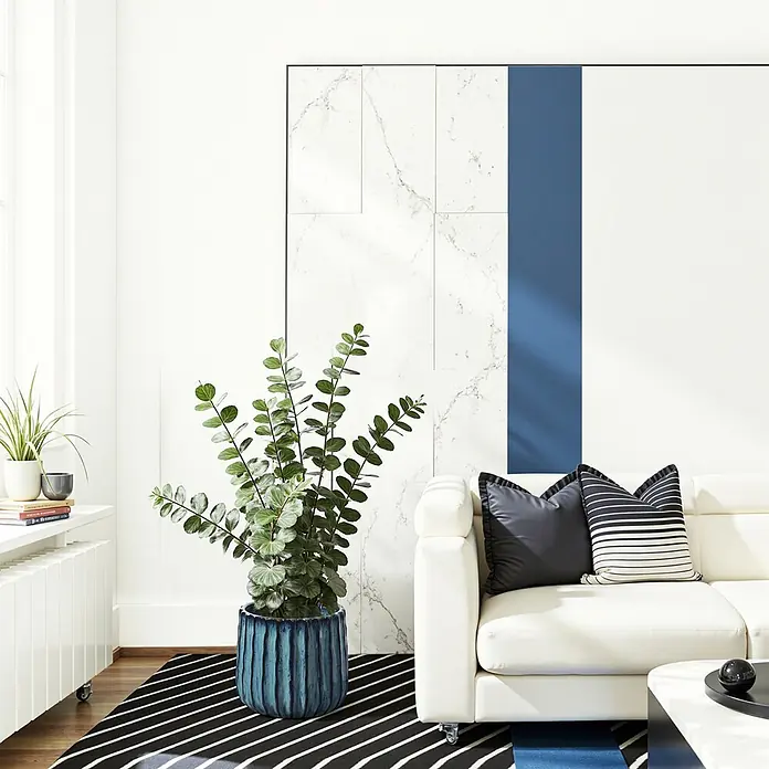 Keramik Blumentopf -  - Große Grünpflanze in einem strukturierten blauen Topf auf gestreiftem Teppich neben weißem Sofa, belebt modernes Wohnambiente.