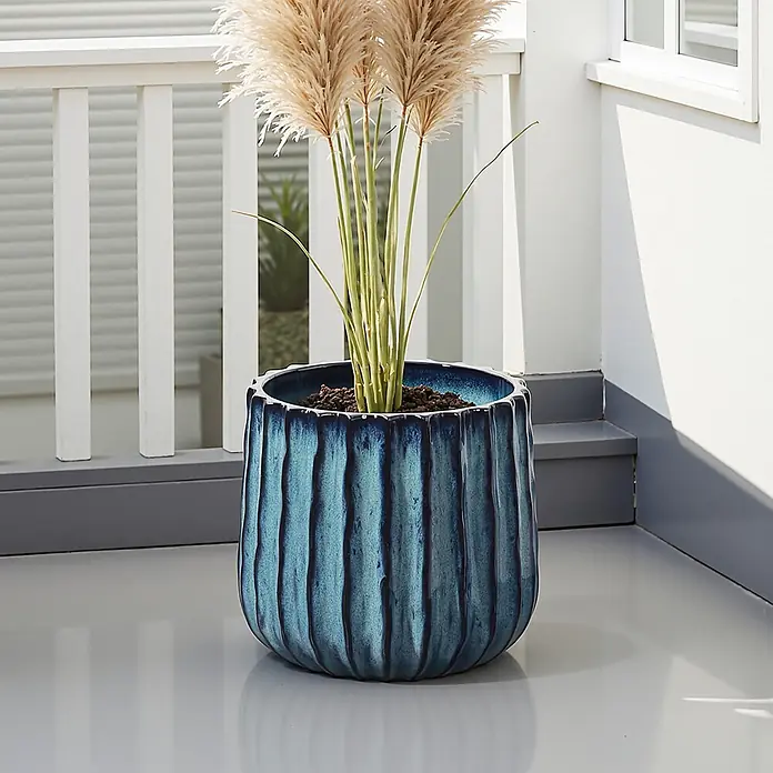 Keramik Blumentopf -  - Blauer Keramik-Pflanztopf mit Pampasgras auf einer Terrasse.