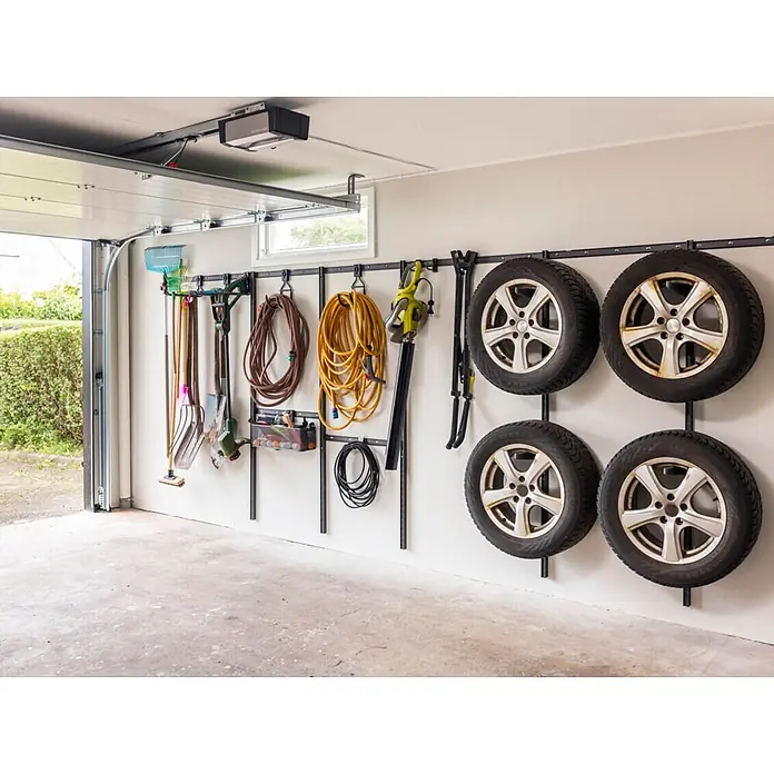 Elfa Garage+ by Elfa Bodenträger für Reifenlagerung - L x B x H: 29 x 1,7 x 5,7 cm, Kunststoff - Schwarzes Metall-Garagenaufbewahrungssystem, mit Gartengeräten, Schläuchen und vier Autoreifen.
