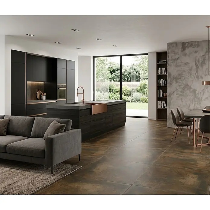 Feinsteinzeugfliese Metallique - 120 x 120 cm, Kupfer, Matt - Moderne offene Küche mit dunklen Schränken, markanter Kupferspüle und passenden dunklen Bodenfliesen, beleuchtet durch Einbauleuchten.