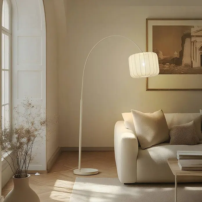 Lindby Stehleuchte Helin - creme / amber, creme / amber, E27 - Weiße Bogen-Stehlampe mit plissiertem Schirm, beleuchtet ein cremefarbenes Sofa.