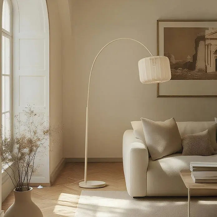 Lindby Stehleuchte Helin - creme / amber, creme / amber, E27 - Gebogene hellbeige Stehleuchte mit geripptem Stoffschirm, über einem cremefarbenen Sofa im Wohnzimmer positioniert.