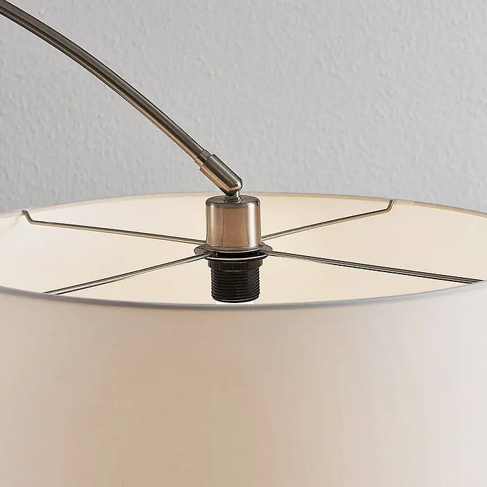 Lindby Stehlampe in nickel satiniert, weiß, Bogenlampe Wohnzimmer -  - Nahaufnahme des gebürsteten Metallarms einer Lampe, der mit einer schwarzen Glühbirnenfassung verbunden ist und einen cremefarbenen Stofflampenschirmrahmen trägt.