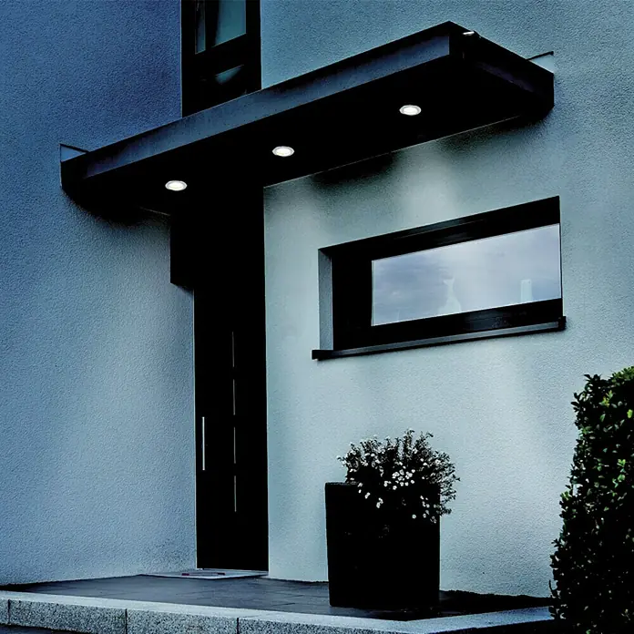 Tween Light LED-Einbauleuchten-Set - 9,6 W, Nickel matt, Warmweiß, IP44 - Fassade eines modernen Hauses mit einer stilvollen Türüberdachung und integrierten Leuchten, die den Eingangsbereich beleuchten.