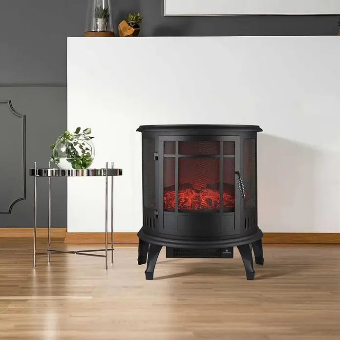 Chimenea eléctrica Tambora - 29 x 56 x 63,5 cm, Negro - Chimenea eléctrica de metal negro con frente de malla, mostrando llamas realistas, situada en una sala de estar moderna.