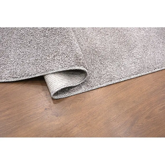 Alfombra de pelo corto Bicolor - Gris, 230 x 160 cm, 100% poliéster - Alfombra gris texturizada, parcialmente enrollada, sobre un suelo de madera marrón cálido.