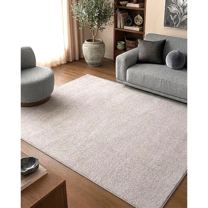 Alfombra de pelo corto Bicolor - Natural, 200 x 140 cm, 100% poliéster - Una alfombra texturizada gris claro cubre el suelo de un salón, colocada bajo un sofá y un sillón grises.