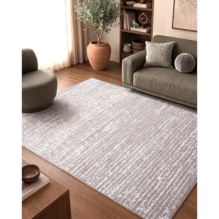 Alfombra de pelo corto Loop - Natural, 230 x 160 cm, 100% poliéster - Una alfombra gris claro con patrón abstracto en un salón moderno.