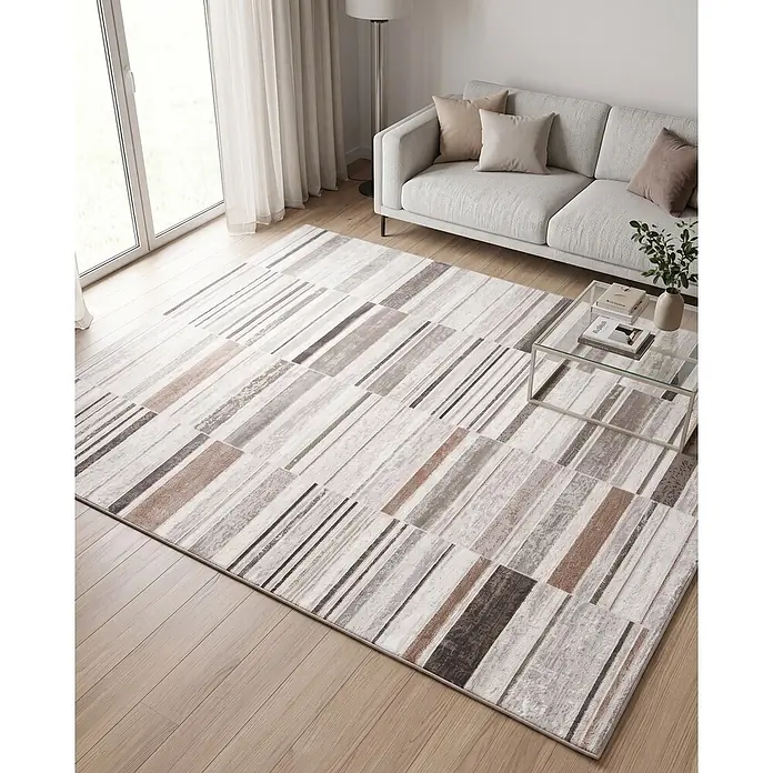 Alfombra de pelo corto Box - Natural, 230 x 160 cm, 100% poliéster - Alfombra abstracta contemporánea con rayas y bloques en tonos blancos, grises y marrones, sobre suelo de madera clara en un salón.