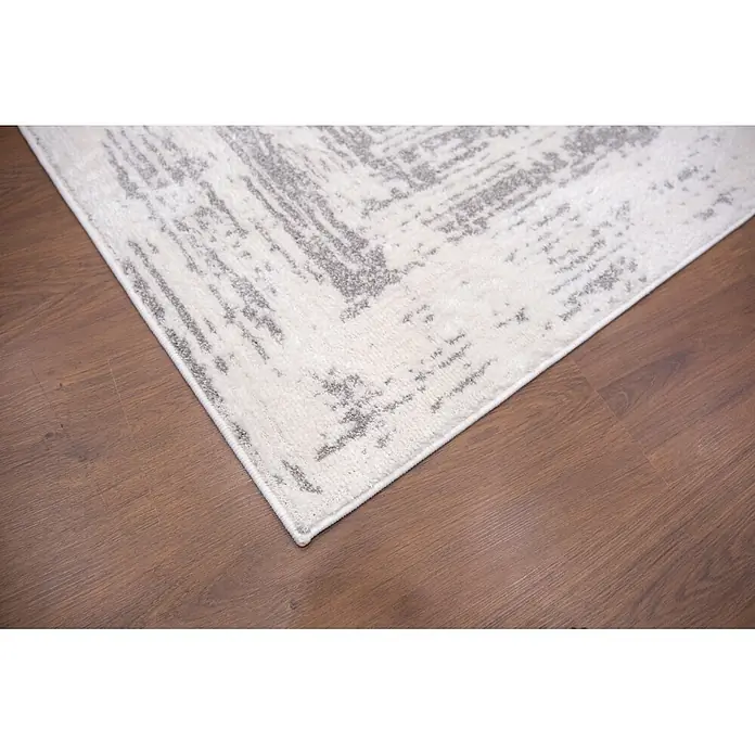 Alfombra de pelo corto Cuadros - Gris, 110 x 60 cm, 100% poliéster - Alfombra con patrón abstracto blanco y gris, colocada sobre un suelo de madera marrón cálido.