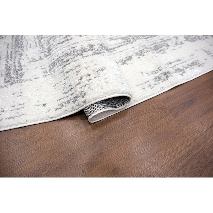 Alfombra de pelo corto Cuadros - Gris, 110 x 60 cm, 100% poliéster - Alfombra suave blanca y gris con patrón, parcialmente enrollada sobre un suelo de madera.