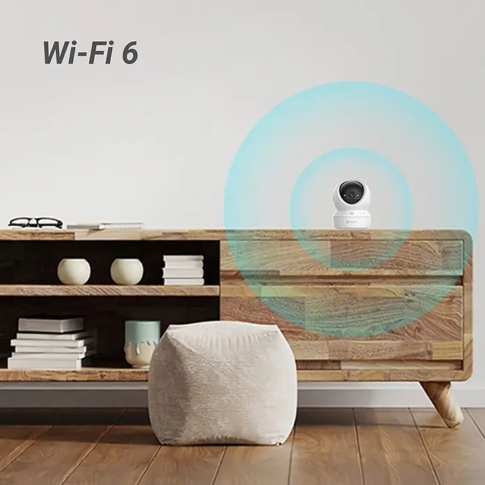 EZVIZ Cámara de vigilancia H6C - Blanco, Ángulo de detección: 360 °, Alcance de detección: 10 m - Cámara de seguridad blanca sobre mueble de madera, con señales Wi-Fi azules y texto 'Wi-Fi 6'.