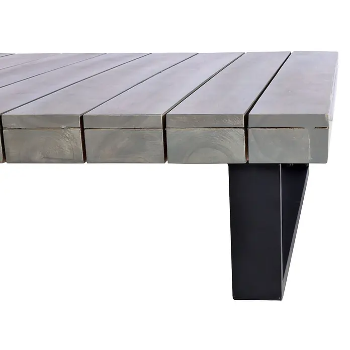 Mendler Loungemöbel-Set HWC-H54 - 2 -tlg., Holz, Grau, Polster dunkelgrau, Grau, Polster dunkelgrau - Nahaufnahme einer hellgrauen, verwitterten Holztischplatte mit dunklem V-förmigem Metallbein.