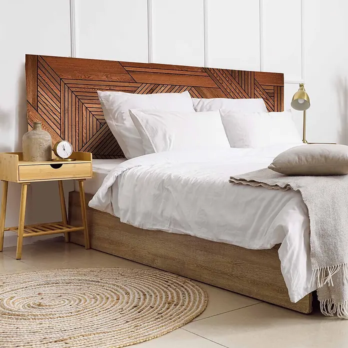 Cabecero de cama Atlas - L x An: 135 x 60 cm, Marrón - Cabecero de madera marrón con un intrincado patrón geométrico, complementando una cama con ropa blanca en un dormitorio moderno.