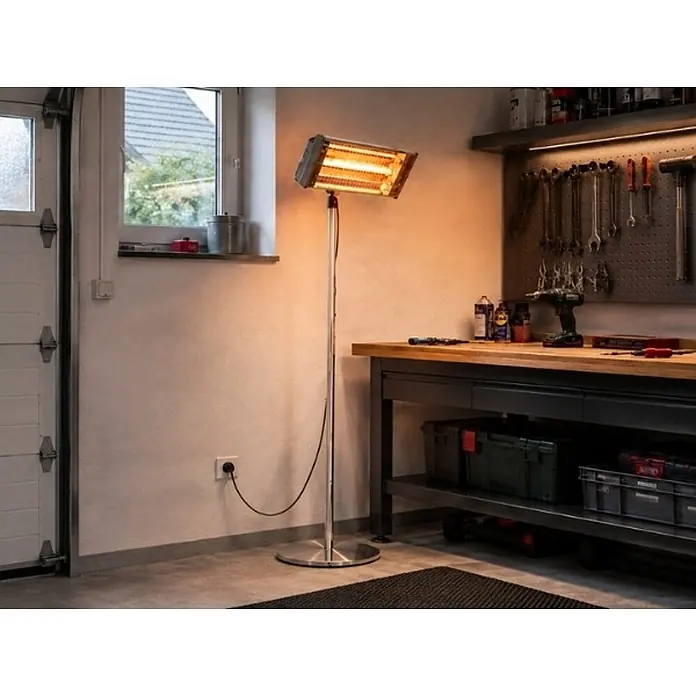 WDH Heizlüfter WDH-240GT Standheizstrahler, Edelstahl mit goldenen Heizröhren - 2,4 kW, Silber, IP55 - Silberner Stand-Infrarotstrahler beleuchtet eine Werkstatt mit warmem Licht.