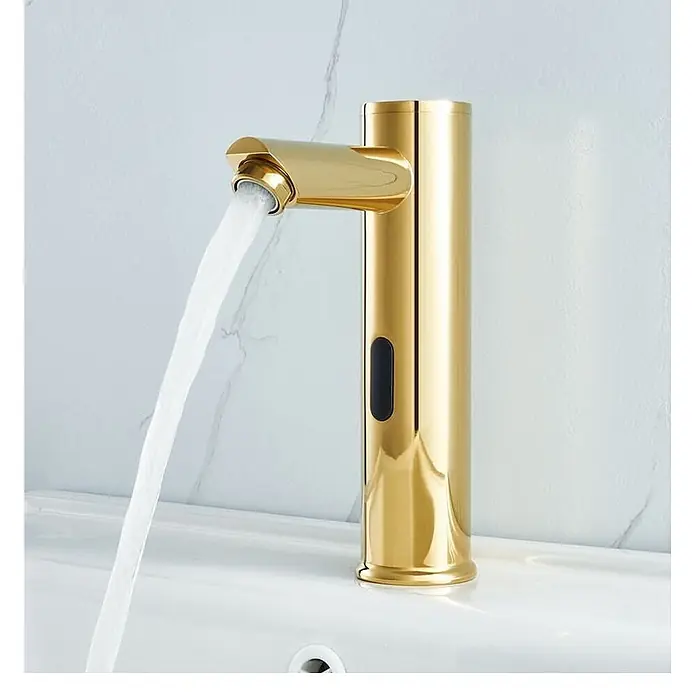 Hudor Waschtischarmatur Scamandre 019 - Hochglänzend - Goldener automatischer Wasserhahn spendet Wasser in ein weißes Waschbecken.