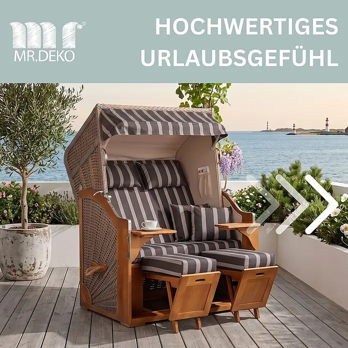 Strandkorb Schleswig Pinie Dessin 554 -  - Ein Doppelsitz-Strandkorb aus braunem Korbgeflecht und Holz mit gestreiften grauen Polstern und ausziehbaren Fußteilen auf einer Terrasse am Meer.