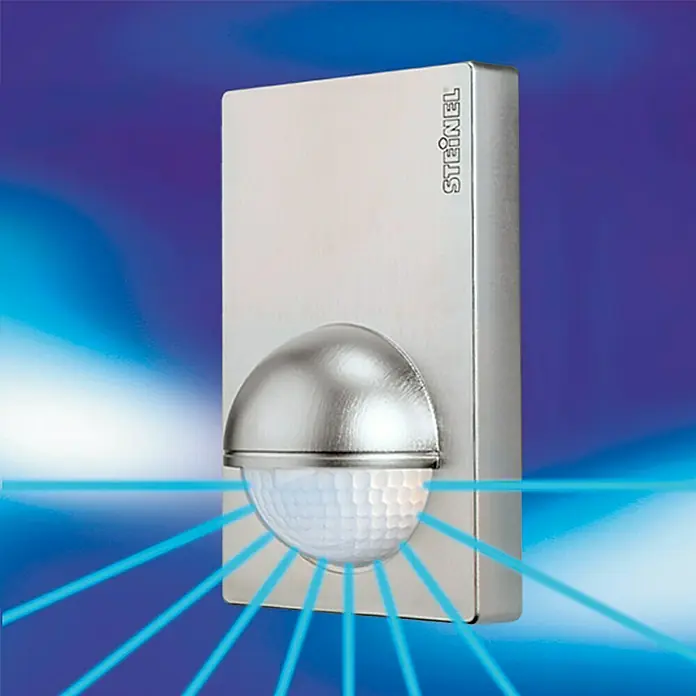 Steinel Bewegungsmelder IS 180-2 silber - Reichweite Sensor: 12 m, Inox-Look, Erfassungswinkel Sensor: 180 °, L x B x H: 56 x 76 x 120 mm - Nahaufnahme eines Steinel Bewegungsmelders aus Edelstahl mit blauen Sensorstrahlen vor blauem Hintergrund.