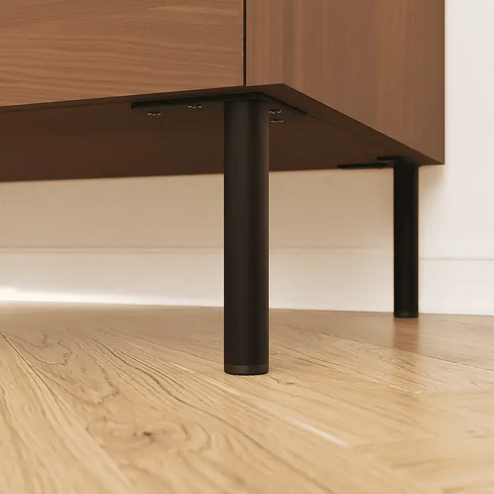HEVVA 4x Möbelfüße - LINZ - Höhe 25 cm,Rund, Schwarz -  - Nahaufnahme eines Holzschranks mit schwarzen zylindrischen Metallbeinen auf Holzboden. Die Beine sind sicher an der Unterseite befestigt.