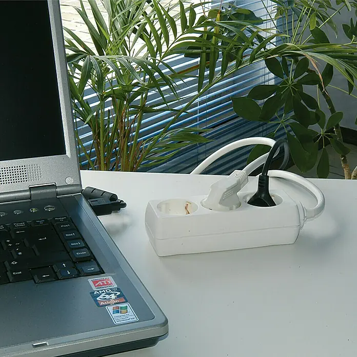 Steckdosenleiste - Anzahl Steckdosen Schuko: 3 Stk., Weiß, Kabellänge: 5 m, Ohne Schalter - Eine weiße Steckdosenleiste mit zwei eingesteckten Netzteilen auf einem Schreibtisch, neben einem Laptop und Grünpflanzen.