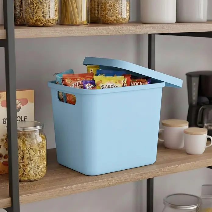 Plastard Aufbewahrungsbox-Set 4er-Set 12,5 Liter in Blau mit Deckel – Stapelboxen, Lagerboxen - L x B x H: 32 x 22 x 24 cm, Kunststoff, Blau, 4 Stk. - Hellblaue Aufbewahrungsbox mit Deckel auf einem Holzregal, gefüllt mit Snacktüten.