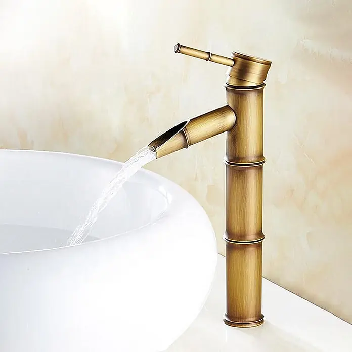 Hudor Waschtischarmatur Artémis 7833 - Seidenmatt - Antik-Messing Wasserhahn im Bambus-Stil, Wasser läuft in ein weißes Waschbecken.