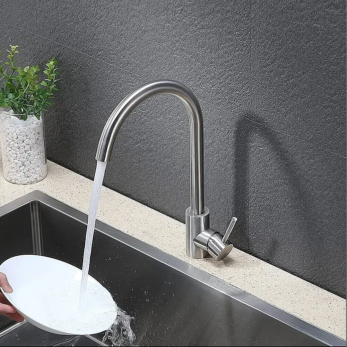 Hudor Spültischarmatur - Seidenmatt - Küchenarmatur aus gebürstetem Edelstahl mit Schwanenhals, die Wasser in ein tiefes Doppelwaschbecken leitet und einen weißen Teller spült.