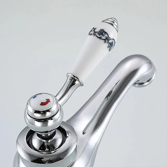 Hudor Waschtischarmatur Erymanthe 062 - Hochglänzend - Verchromter Wasserhahn mit weißem Keramikgriff, blauen Mustern und rot/blauem Temperaturanzeiger.